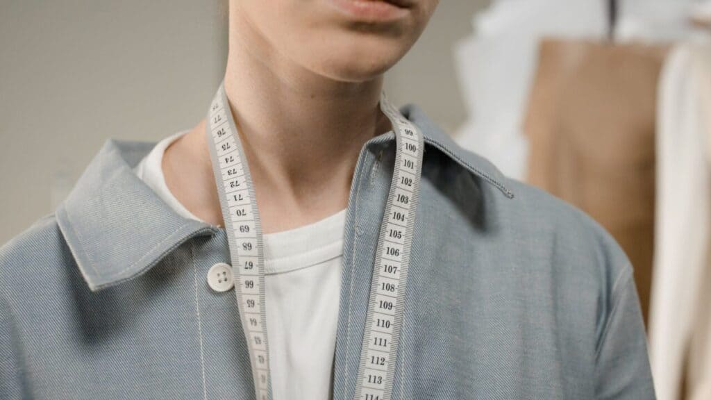 Cloth measuring tape draped around a person's neck, used to check neck circumference