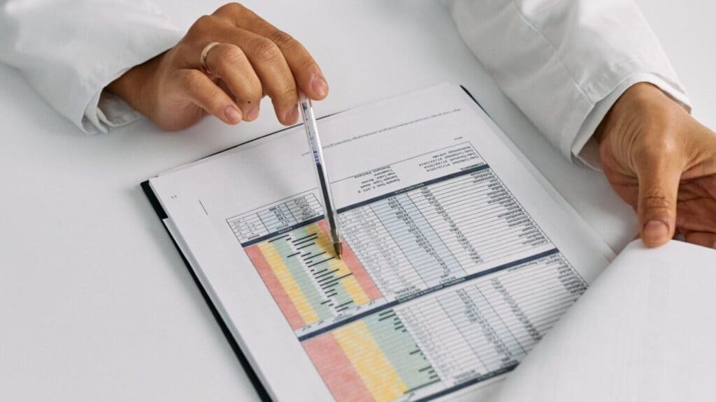 Doctor pointing a pen at a color-coded results chart while reviewing study data
