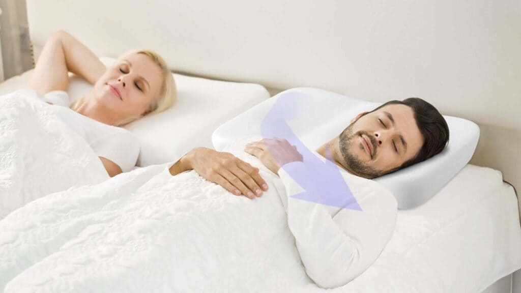 Man sleeping on his side on a Nitetronic Z10 contour pillow beside a sleeping woman