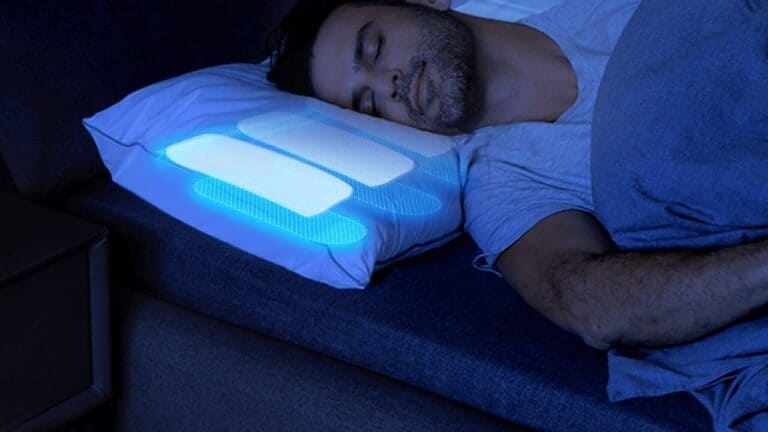 Man asleep on the glowing blue air chambers of a Nitetronic Z6 smart anti-snore pillow