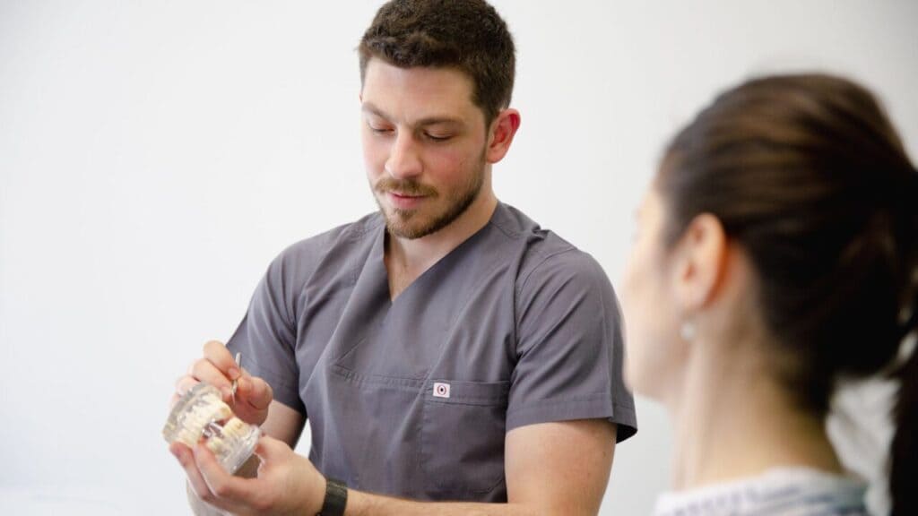 Dentist showing a dental model to a patient in a clinic