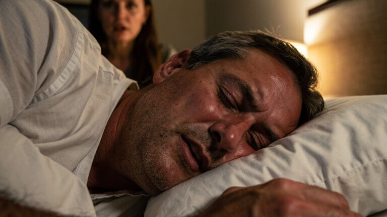 Man snoring, woman watching